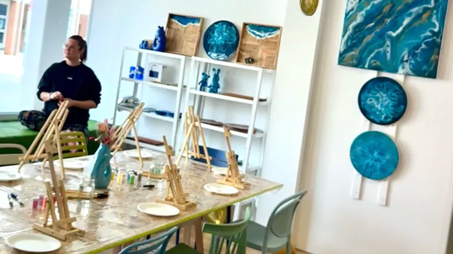 Art studio with easels, paints, and artwork displayed.