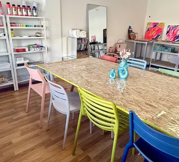 Art studio with colorful chairs and table.