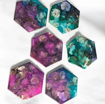 Bunte hexagonale Untersetzer auf weißer Oberfläche.