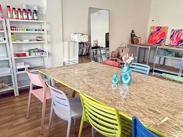 Art studio with colorful chairs and supplies.