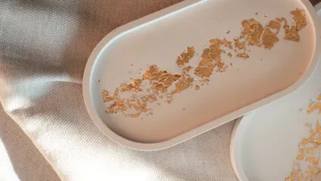 White trays with gold leaf, on fabric.