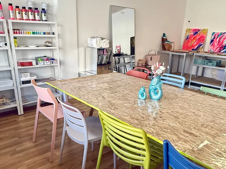 Kunststudio mit bunten Stühlen und Materialien.