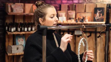 Frau organisiert Handwerk in rustikalem Laden.