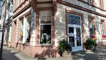 Corner shop with large windows and sign outside.