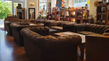 Brown leather sofas in cozy, well-lit store.