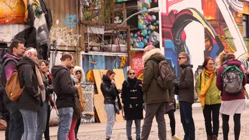 Gruppe steht vor bunten Graffiti-Wänden.