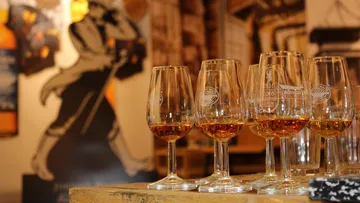 Glasses of whisky on a wooden table.