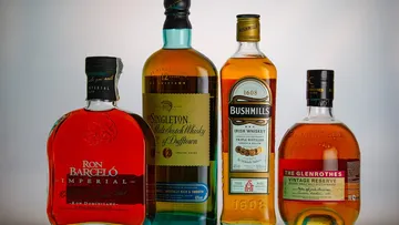 Vier Whiskey- und Rumflaschen ausgestellt.