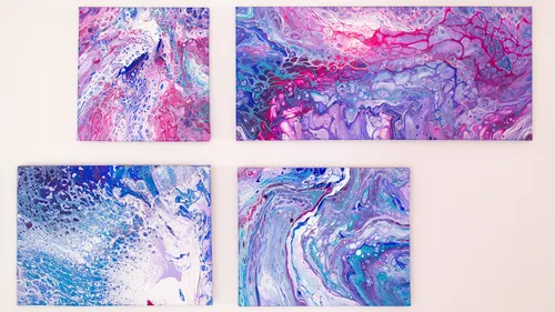 Four abstract paintings with blue and pink swirls.