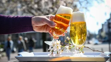Hand hält Bierglas, Außenbereich.