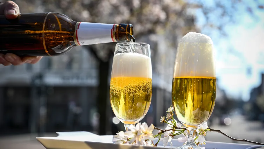 Beer poured into glass in outdoor setting.