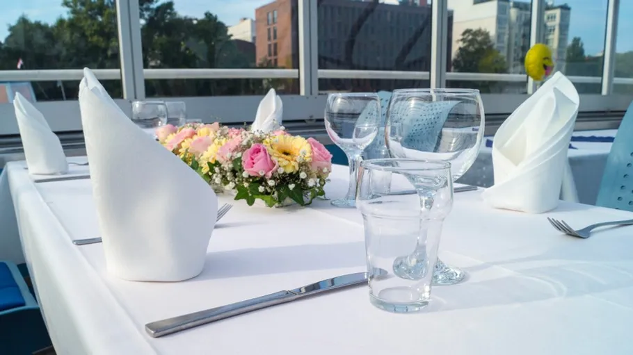 Elegantly set dining table with flowers indoors.