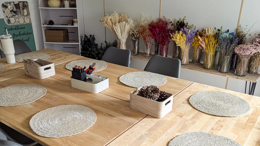 Craft table with placemats and dried flowers.