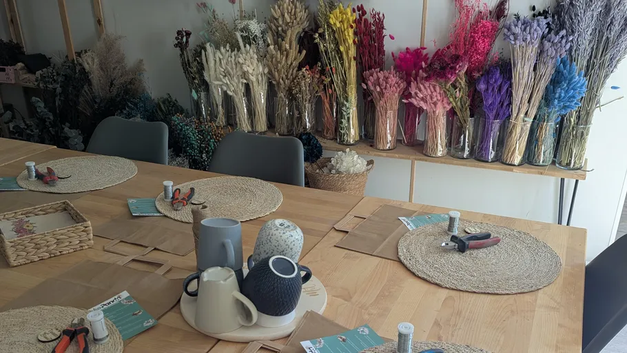 Craft table with dried flowers in vases.