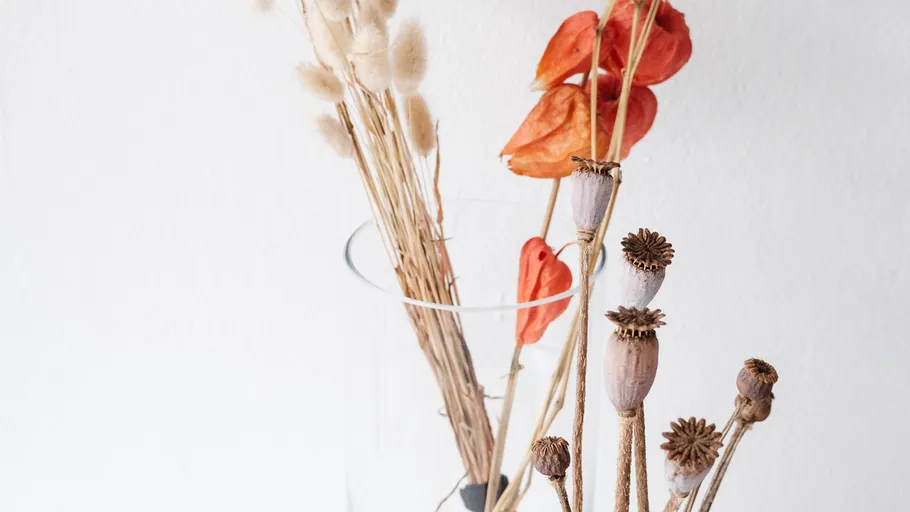 Dried flowers in a clear glass vase.