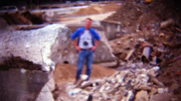 Blurred person standing amidst construction debris.