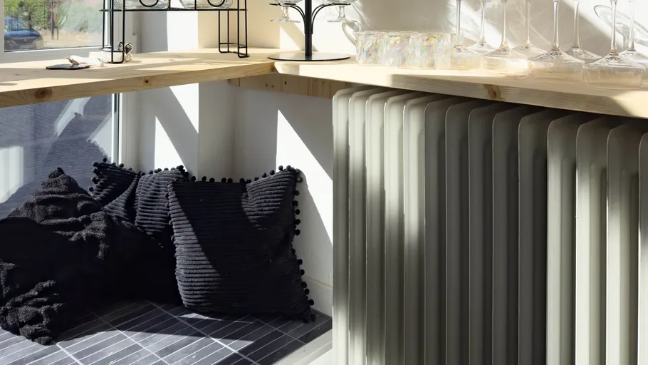 Corner nook with pillows and radiator.