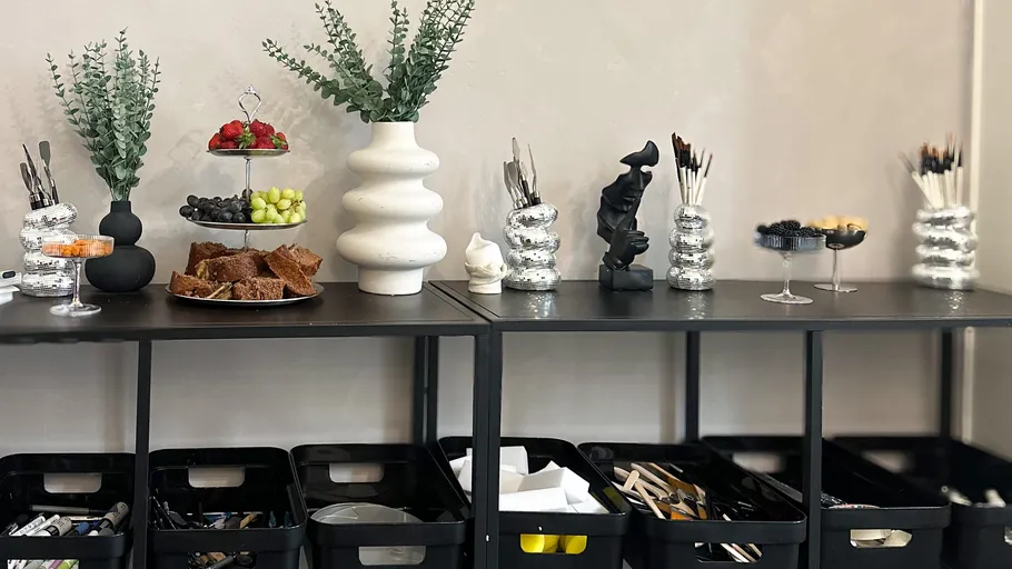 Modern buffet table with food and art supplies.