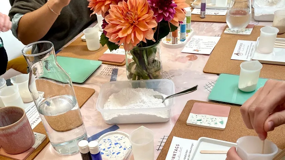 People crafting at a table with flowers.
