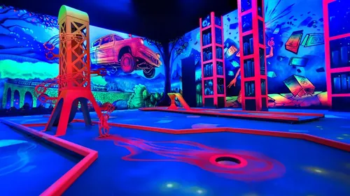 Glowing mini-golf course with vivid murals.