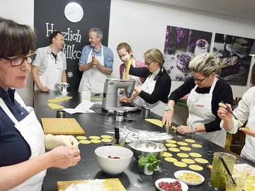 Kochkurs mit mehreren Personen, die frische Pasta zubereiten.