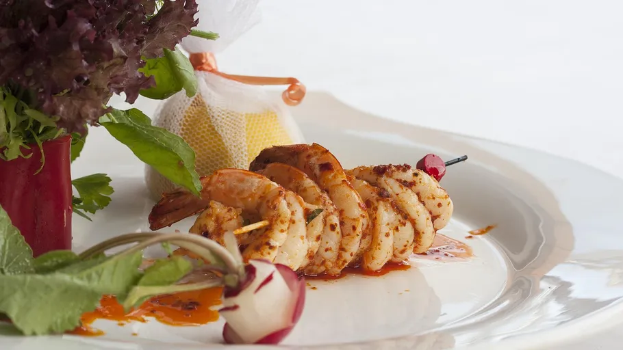 Grilled shrimp skewers on a garnished plate.