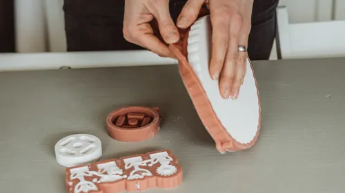 Hände entfernen Objekt aus Silikonform auf Tisch.