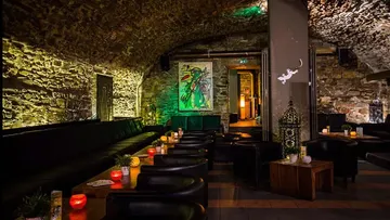 Gemütliche Lounge mit Steinbögen und Kerzen.