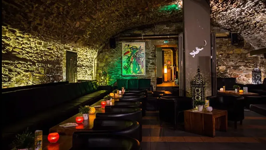 Cozy lounge with stone arches and candles.