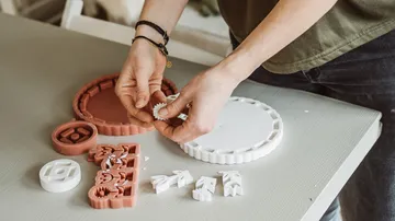 Person assembling puzzle pieces on a table.