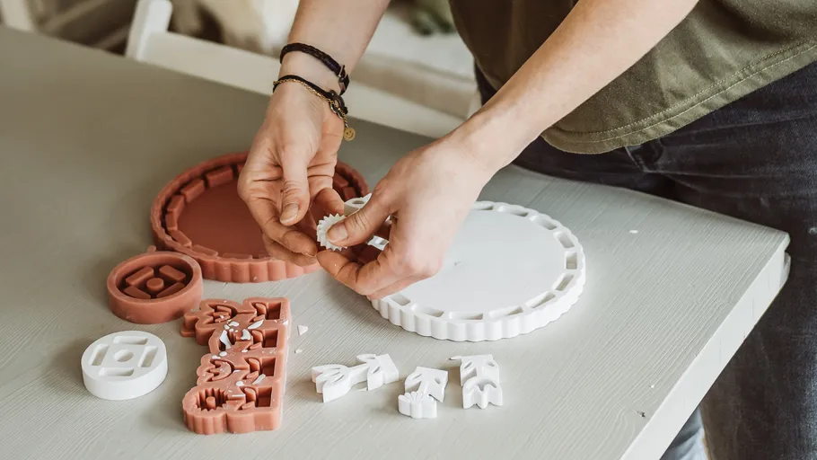 Person assembling puzzle pieces on a table.