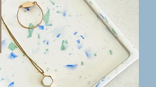 Goldschmuck auf einem gesprenkelten Tablett.