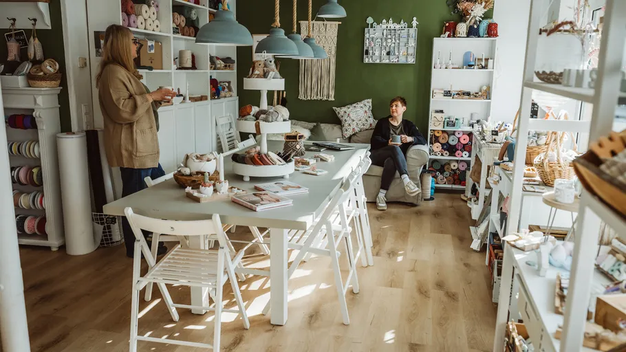 Women conversing in cozy craft shop.