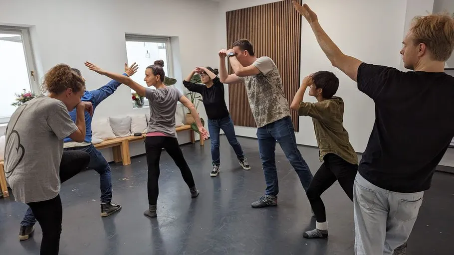 Gruppe übt Theaterposen im Studio.