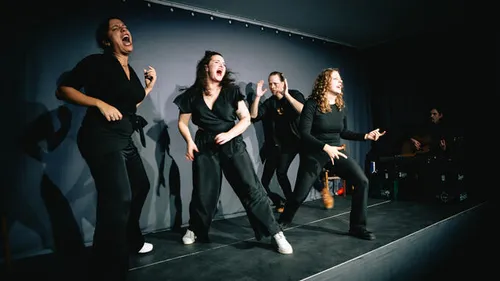 Performers energetically acting on a dark stage.