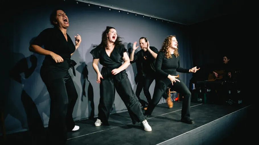 Performers energetically acting on a dark stage.