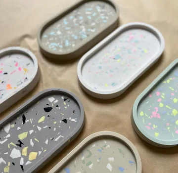 Bunte Terrazzo-Tabletts auf braunem Papier angeordnet.