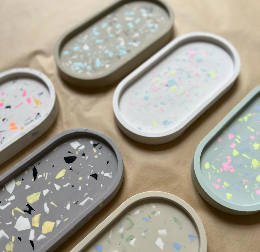Bunte Terrazzo-Tabletts auf braunem Papier angeordnet.