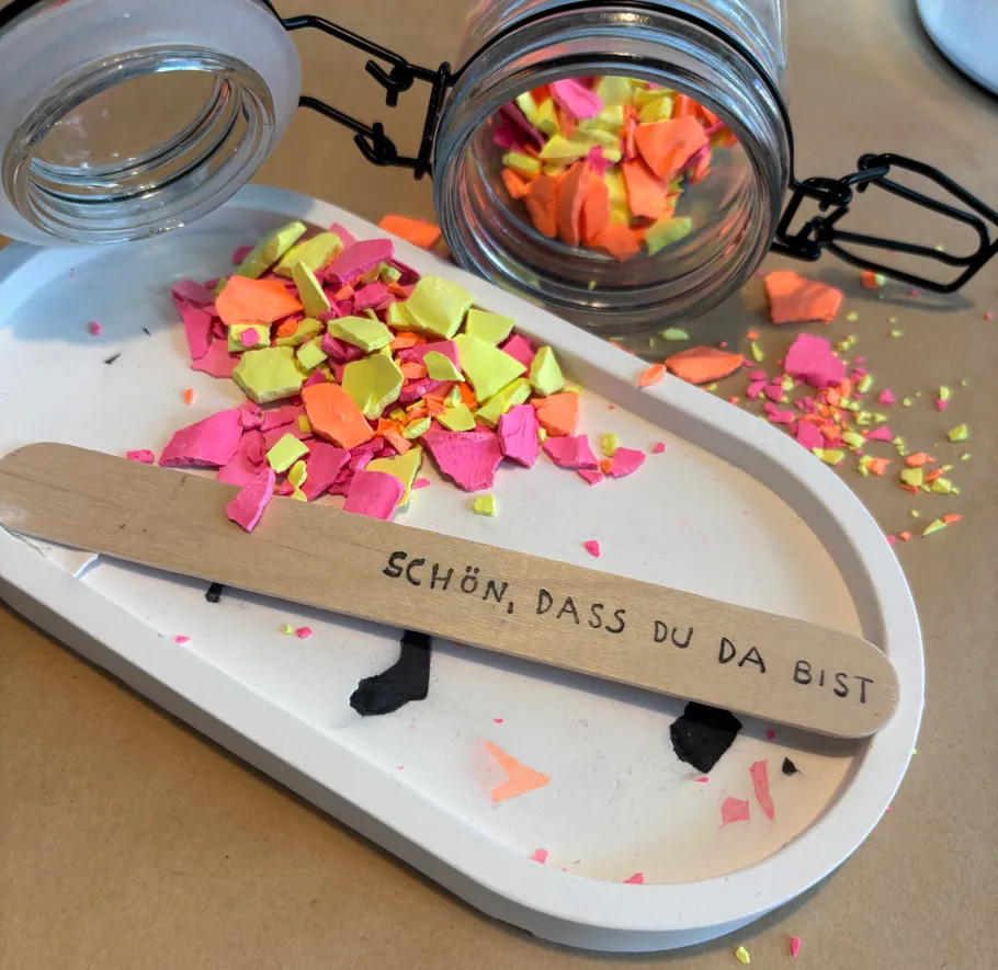 Colorful fragments spill from glass jar.