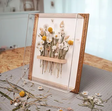 Framed pressed flowers on a crafting table.