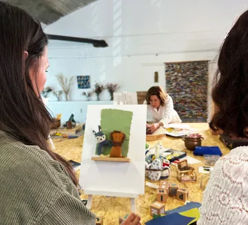 People crafting at table with art supplies.