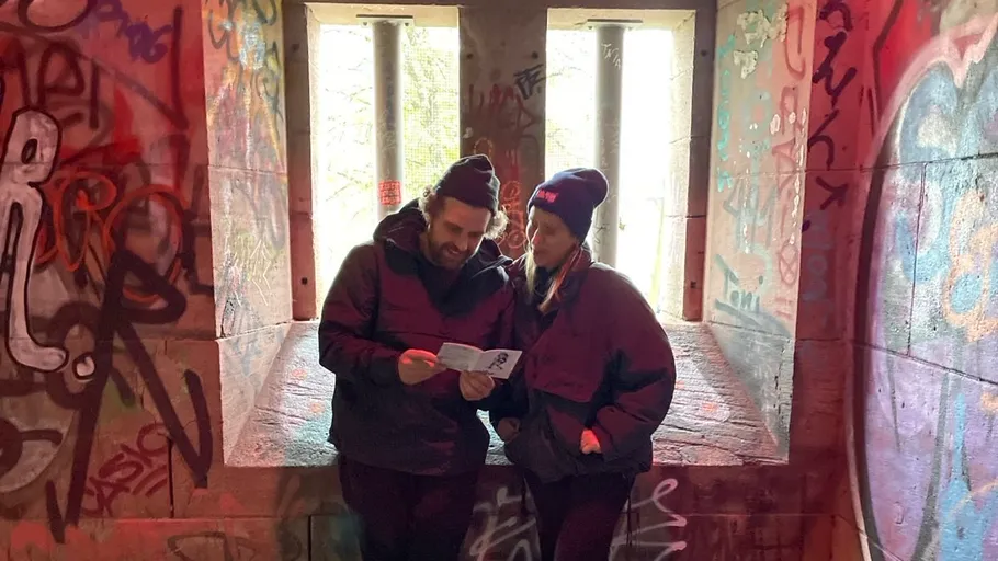 Zwei Personen lesen vor Graffiti.