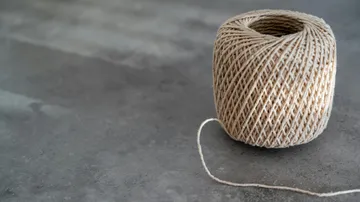 Twine spool on a gray surface.
