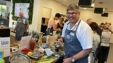Man smiling while cooking in a kitchen.