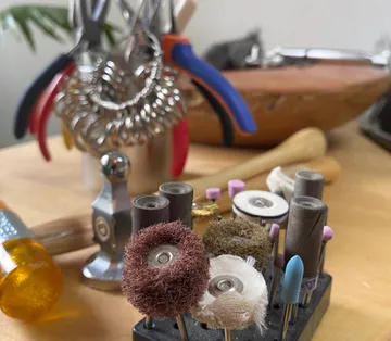 Jeweler's tools with polishing attachments on desk.