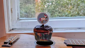 Cupcake mit Einhorn-Deko auf Gitarre, Fensterblick.
