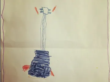 Kind zeichnet einen Dalek auf Papier.