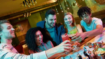 Gruppe von Freunden stößt in einer Bar an.