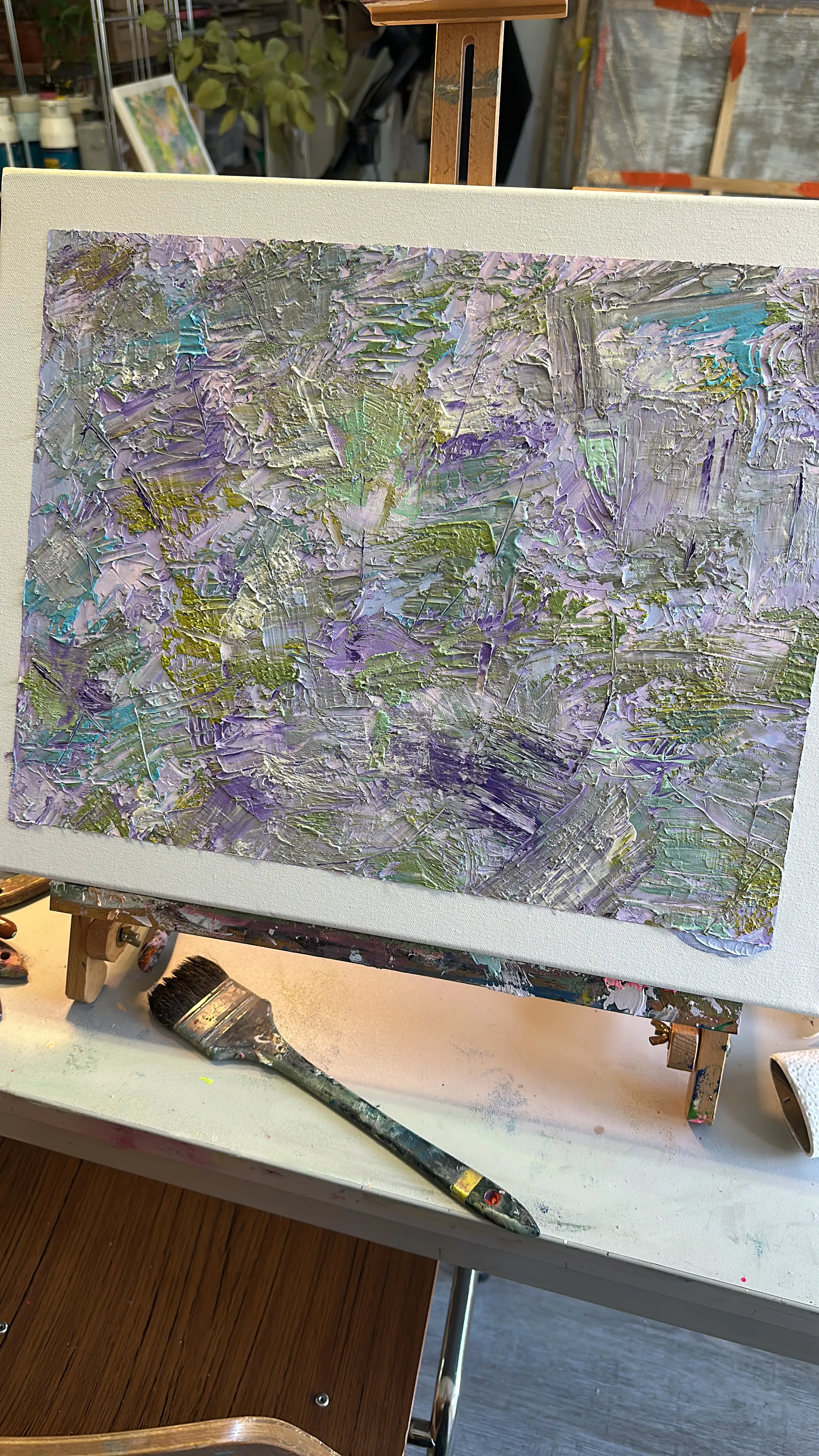 Abstraktes Gemälde mit strukturierten lila und grünen Pinselstrichen.