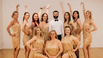 Group of dancers posing together indoors.